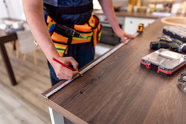 istock Skilled worker measuring wooden surface for precise cuts in modern kitchen renovation project 2230490324