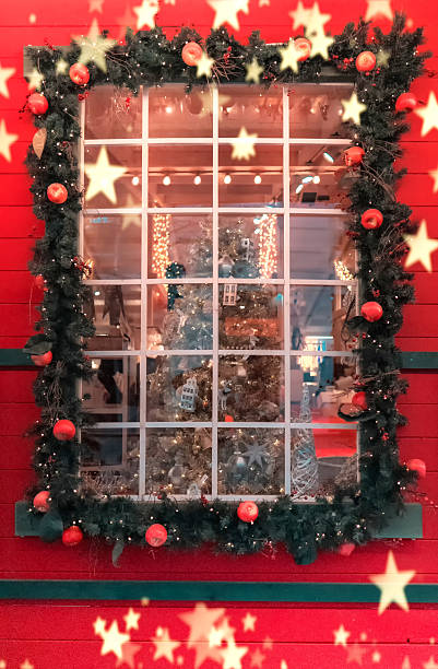 Festive christmas window display showcasing a decorated christmas tree, garland, ornaments, and warm lighting, creating a cozy holiday atmosphere