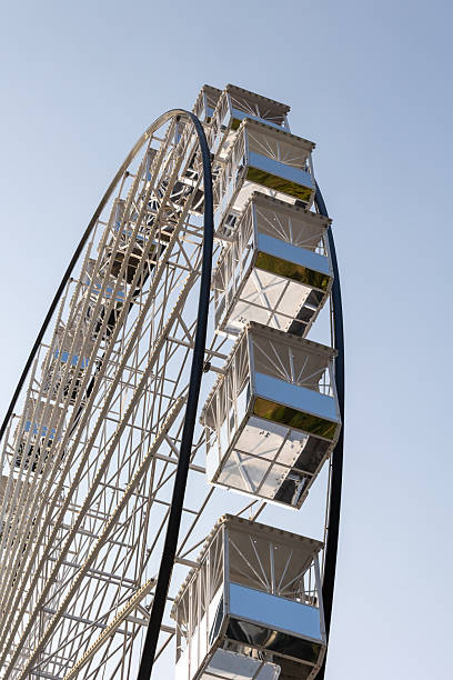 istock Ferris wheel gondolas reflecting blue sky on a sunny day 2230496793