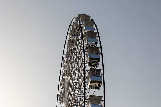istock Ferris wheel with empty cabins against a clear sky 2230496794