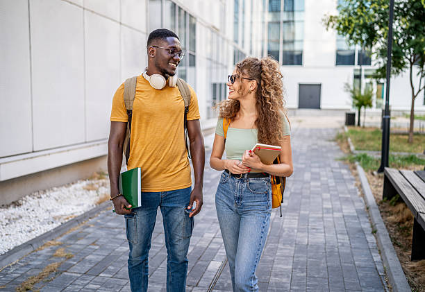 istock Two smiling students walking and talking outdoors 2230498628