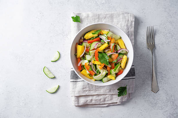 istock Cucumber red onion mango red bell pepper salad in a bowl 2230498769