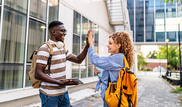 istock Happy students giving high five outdoors 2230499837