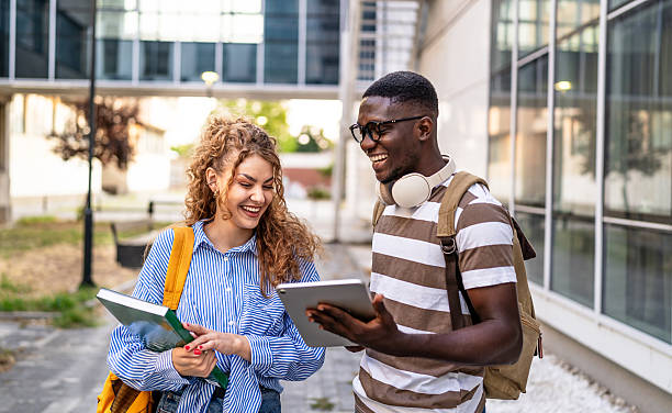 istock Cheerful students walking and talking outdoors 2230499873