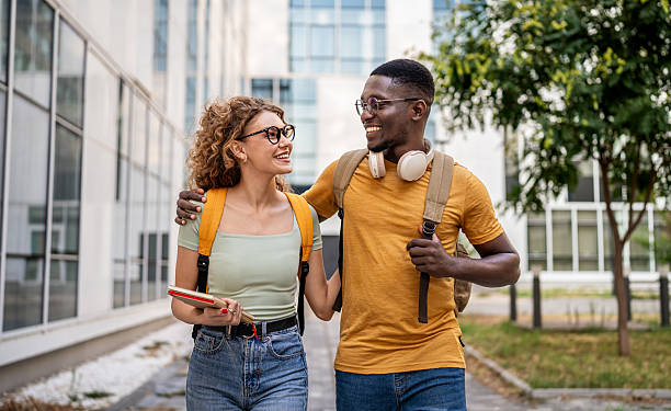 istock Cheerful students walking and talking outdoors 2230500803
