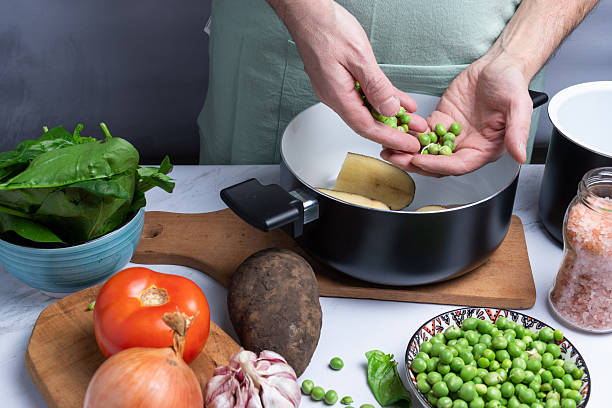 istock Taking green peas among other vegetables for cooking. 2230501100