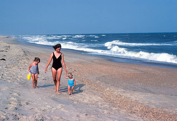 istock Cape Hatteras NS - Mother & Daughters Walk Along Shore - 1983 2230502320
