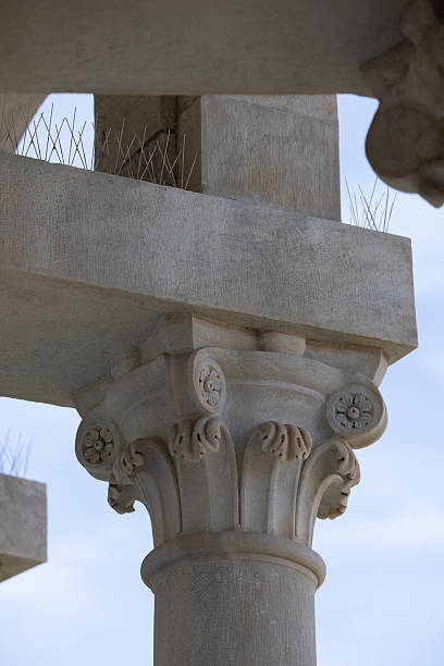Partially preserved corinthian column rising against a clear blue sky at the Kourion archaeological site in Cyprus, a testament to ancient architecture