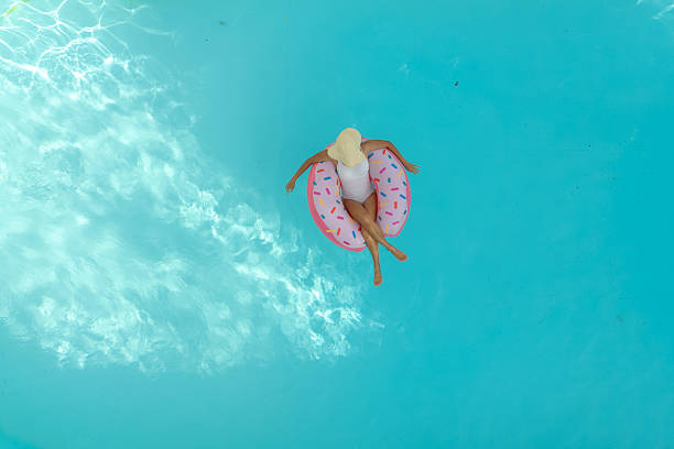 istock Girl in the pool with inflatable swim ring 2230510825