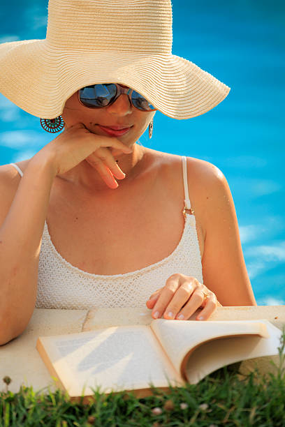 Lady reading by the swimming pool