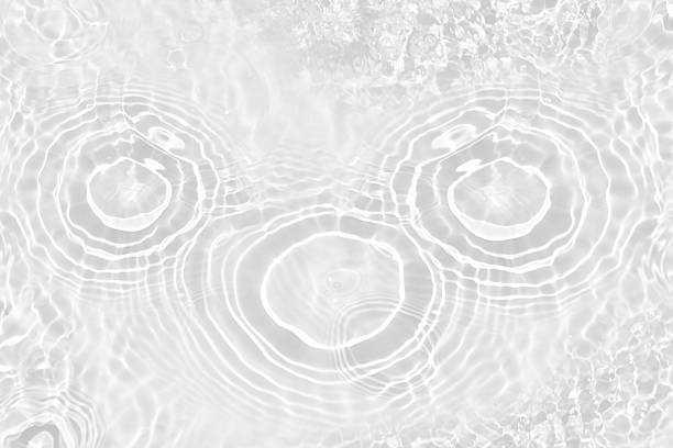 istock White water with ripples on the surface. Defocus blurred transparent white colored clear calm water surface texture with splashes and bubbles. Water waves with shining pattern texture background. 2230524237