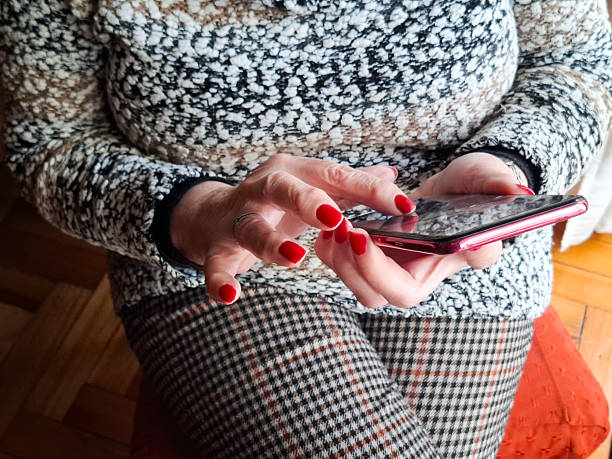 Senior woman using smart phone while sitting at home