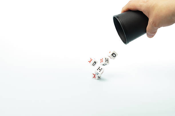 istock Hand throwing poker dice from black cup on white background 2230532141