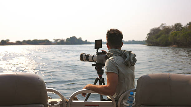 istock Photographer on Boat Capturing River Views with Professional Camera Equipment 2230541734