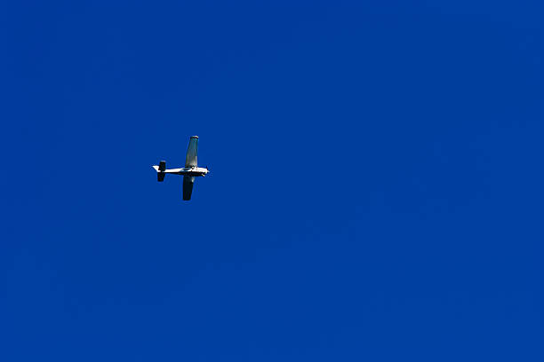 istock Small Airplane Flying in Clear Blue Sky 2230542280