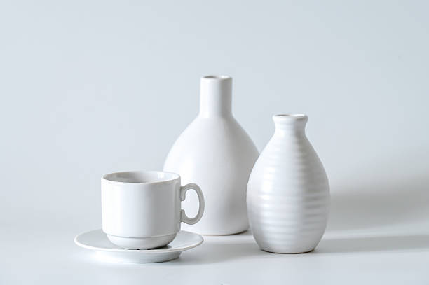 istock White coffee cup and saucer, white vases on a white background. 2230542343