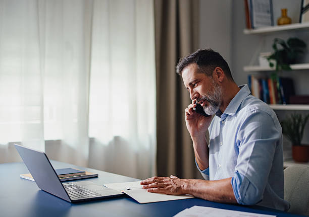 istock Businessman Working in Home Office While Talking on the Phone 2230546978