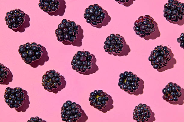 istock Pattern of fresh blackberries on pink background. 2230549409