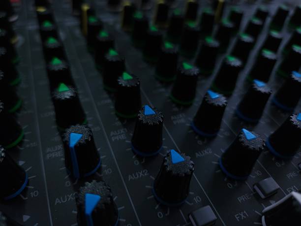 istock Close up of an audio mixing console with multiple control knobs and buttons for sound adjustments. 2230549877
