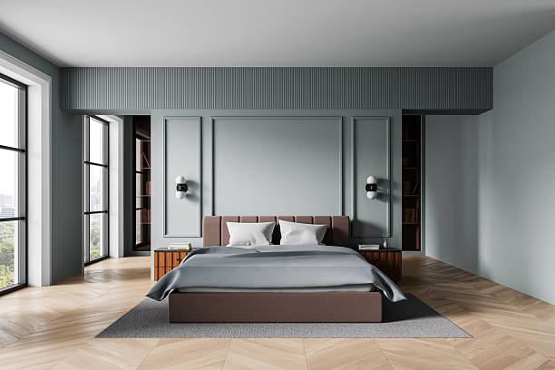istock Modern bedroom interior with minimalist design, elegant bed and soft lighting, large windows with city view, wood floor and pastel wall panels. 3D Rendering 2230552660