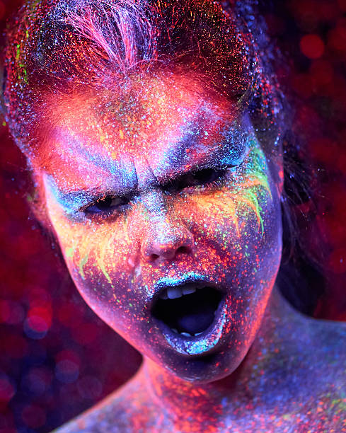 istock Bizarre Woman with Eccentric Fluorescent Makeup Is Screaming on Starry Space Backdrop 2230552726