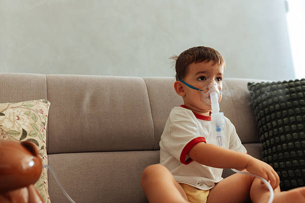 istock Little boy using a nebulizer mask for inhalation at home 2230554832
