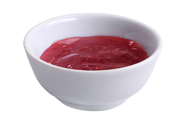 Sauce bowl with raspberry jam on isolated white background