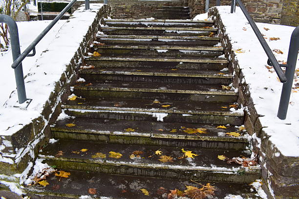 istock fallen leaves and snow on stairs 2230557885