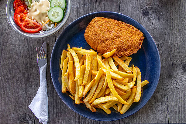 istock Chicken schnitzel with chips and salad on a plate 2230558959