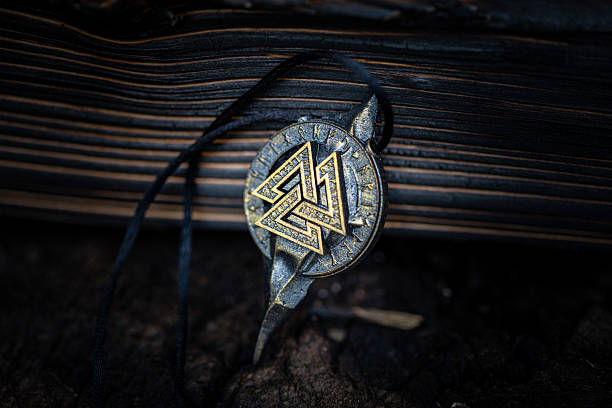 istock Ancient Nordic Symbol - Valknut Rune Design on dark aged background 2230565320