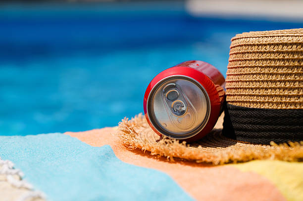 Poolside seat at the hotel. Cold drink and straw hat by the pool.