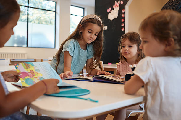 istock Beautiful children reading books in kindergarten 2230569543