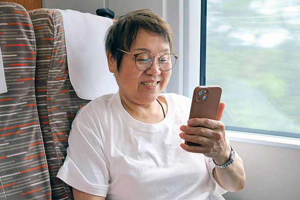 istock An elderly Asian woman was using her mobile phone on the high-speed train. 2230573461