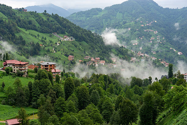 istock Fog Slowly Rising from the Green Valley Surrounded by Mountains 2230574806