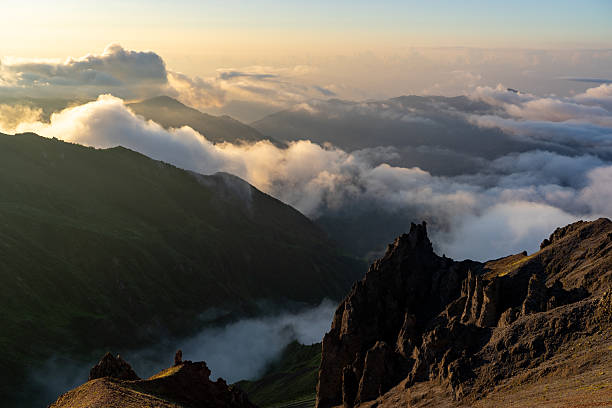 istock Clouds rolling over mountain peaks at sunrise creating a breathtaking landscape 2230580024