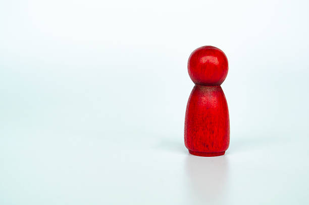 istock A lone red figure distant from wooden groups, representing leadership or rejection or exclusion concept 2230580145