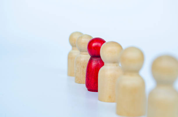 istock A red figure aligned with other wooden figures, representing leadership or marginalization or discrimination concept. 2230580211
