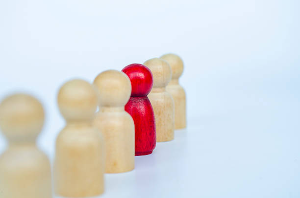 istock A red figure aligned with other wooden figures, representing leadership or marginalization or discrimination concept 2230580212