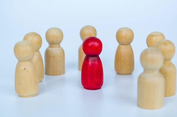 istock A red figure positioned among wooden groups equally, representing inclusion and diversity of it can also be discrimination concept 2230580246