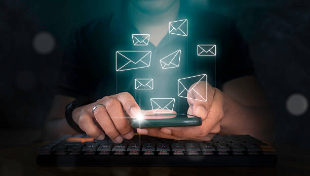 istock Man holding smartphone with virtual screen and email icon floating off the screen. Email concept. 2230580431