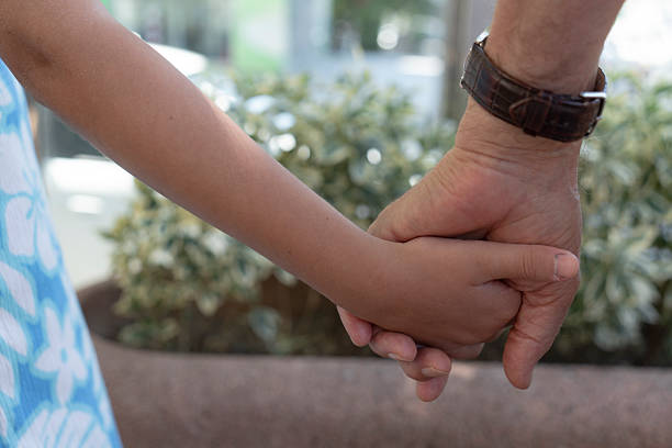 istock Little girl holding an unrecognizable man’s hand 2230580999