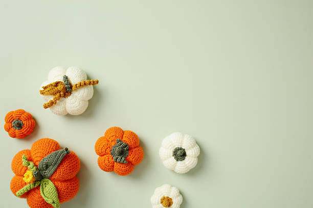 istock Minimalist autumn composition with handmade crochet pumpkins on pastel background 2230581125