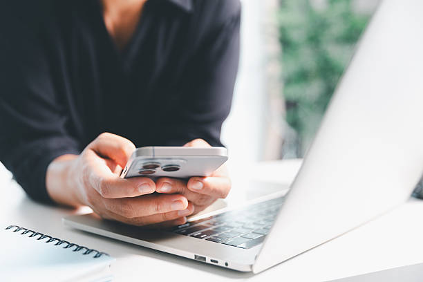istock Close-up scene, a female seated at a table holds a smartphone, spending time on modern e-date services and social media through a mobile app, illustrating the wireless concept of digital usage. 2230583548
