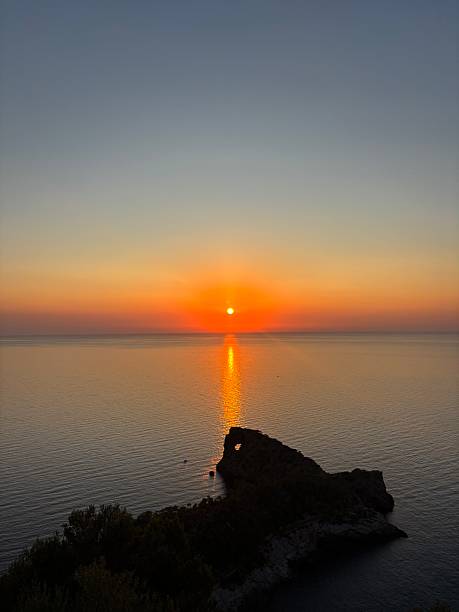 View of the sunset from Mirador Sa Foradada in Mallorca, Spain. The photo shows dramatic cliffs, golden sunlight reflecting on the sea, and the peaceful Mediterranean landscape. Perfect for travel, tourism, and nature photography, highlighting the natural beauty and calm atmosphere of Mallorca.