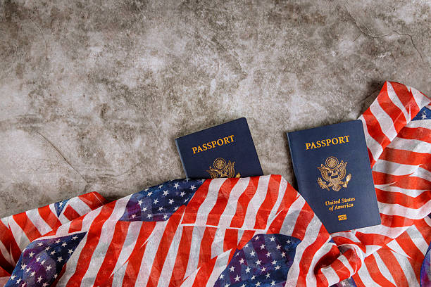 istock Two United States passports resting on an American flag patterned blanket on textured surface 2230589832