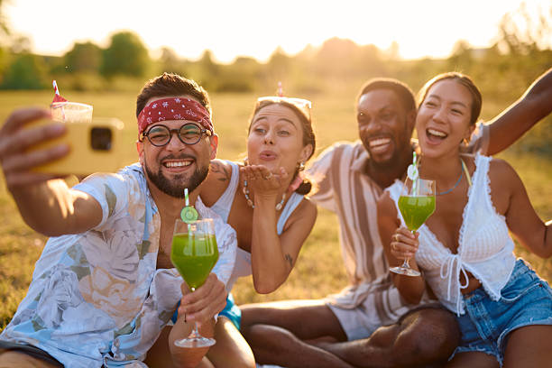 istock Group of cheerful friends taking selfie while having picnic in nature 2230591414