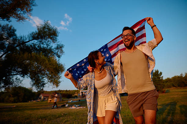 istock Young couple running with american flag during sunset 2230591758
