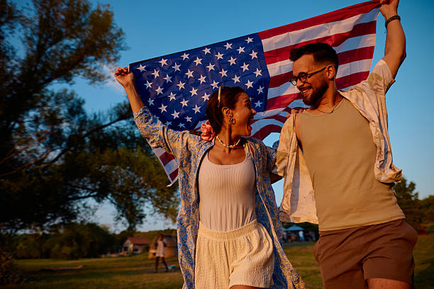 istock Young couple running with american flag at sunset 2230591790