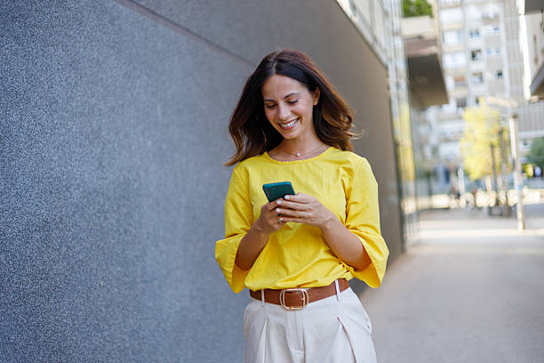istock Professional female worker texting on smartphone while navigating urban street with confident stride 2230595792