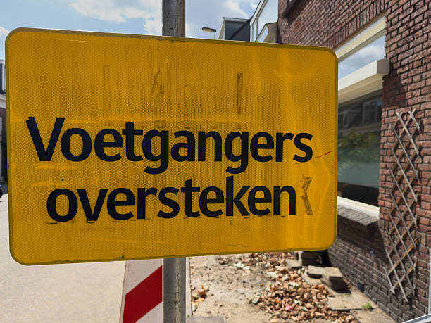 istock Bright yellow pedestrian crossing sign stands prominently against a brick wall, emphasizing safety and awareness for pedestrians in urban environments 2230596184